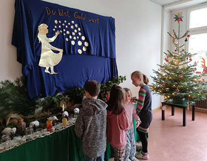 Schulkinder betrachten die Krippe